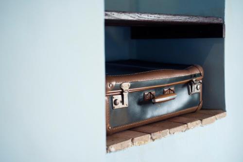 a brown suitcase sitting on a brick ledge at Il Nibbio - Casa dell'artista in Morano Calabro