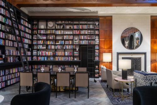 a library with a table and chairs and bookshelves at Heathman Hotel in Portland