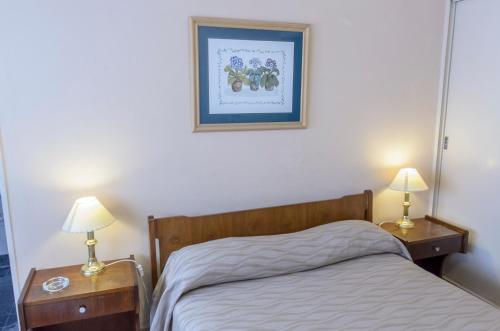 1 dormitorio con 1 cama y 2 mesitas de noche con lámparas en Hotel Marydor en La Falda