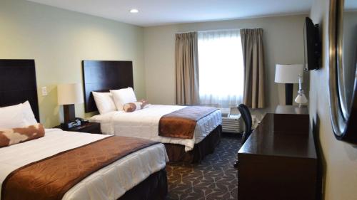 a hotel room with two beds and a window at America's Best Value Inn - Memphis Airport in Memphis