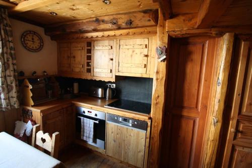een keuken met houten kasten en een fornuis met oven bij Appartement duplex de charme hyper centre à Val d'Isère in Val dʼIsère