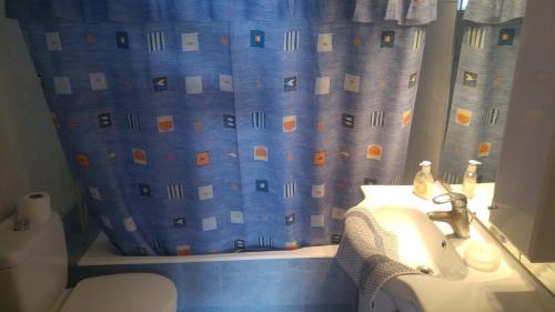 a bathroom with a sink and a shower curtain at Kamares Apartments ΕΕ in Poros