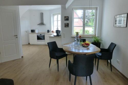 uma cozinha e sala de jantar com mesa e cadeiras em Ferienwohnung am Eifelsteig em Roetgen