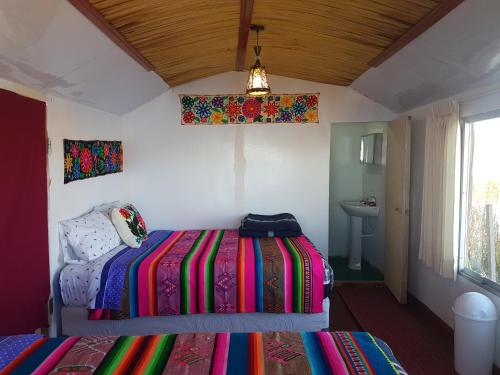 a bedroom with a bed with a colorful blanket at Uros Lake Titicaca Lodge in Puno