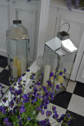 a glass container with candles and purple flowers on a floor at Edinburgh37 in Edinburgh