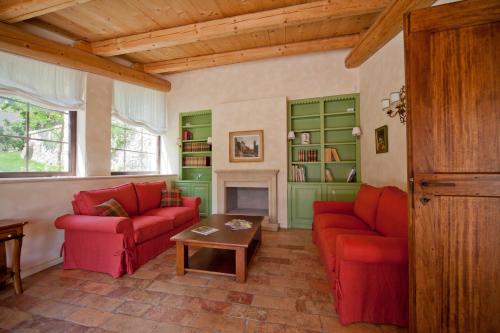 a living room with two red couches and a fireplace at Antico Casale Bergamini in SantʼAmbrogio di Valpolicella