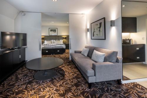 a living room with a couch and a table and a bed at The George in Christchurch