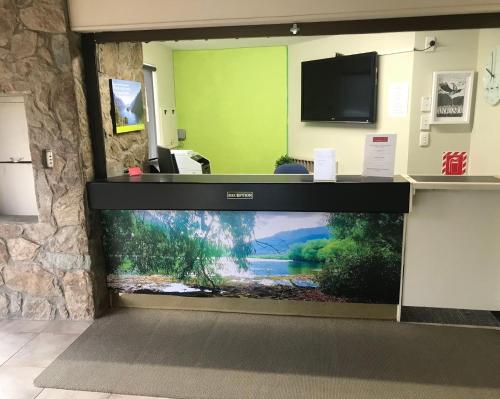 a large aquarium in a room with a tv at Earnslaw Lodge in Queenstown