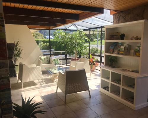 a conservatory with white chairs and a table and windows at Earnslaw Lodge in Queenstown