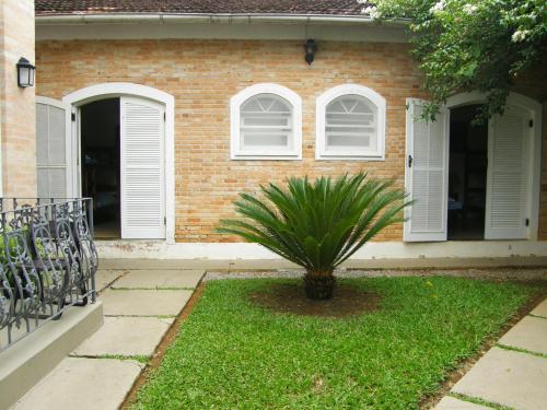 a house with a palm plant in front of it at Pousada Omnimare in Ubatuba