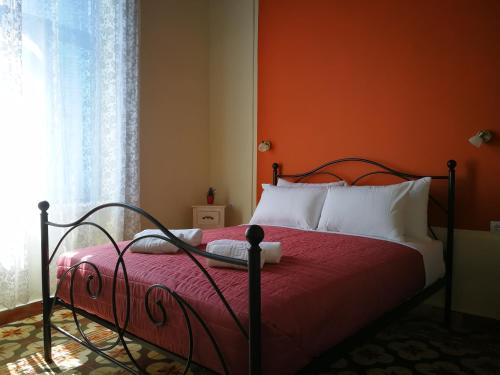 a bedroom with a bed with an orange wall at Apollon Hotel in Chania