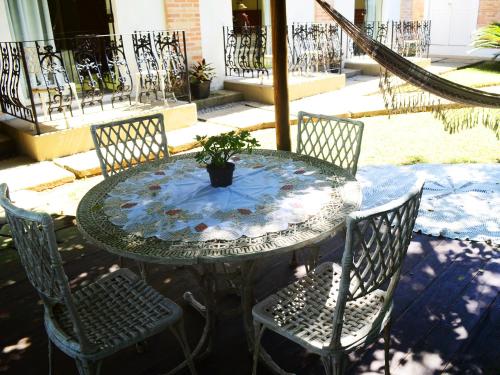 a glass table and chairs with a potted plant on it at Pousada Omnimare in Ubatuba