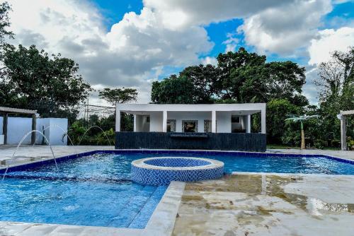 uma piscina com um pavilhão ao lado de uma casa em Hotel Finca Naranjal em Granada