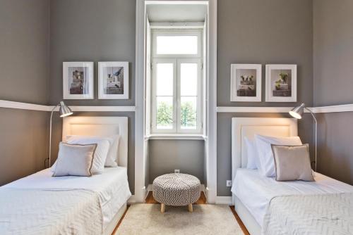 dwa łóżka w pokoju z oknem w obiekcie Saboia Terrace 515 by Saboia Collection w mieście Monte Estoril