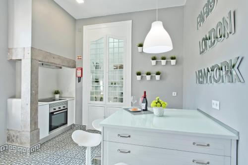 a kitchen with a white island and a fireplace at Saboia Terrace 515 by Saboia Collection in Monte Estoril