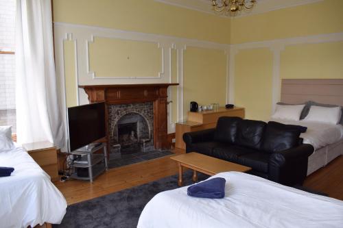a living room with a couch and a fireplace at Ardgowan Guest House in Edinburgh