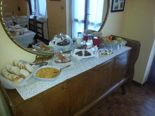a buffet with food and a mirror in a room at Spighe Paglia e Girasole in Candia Canavese