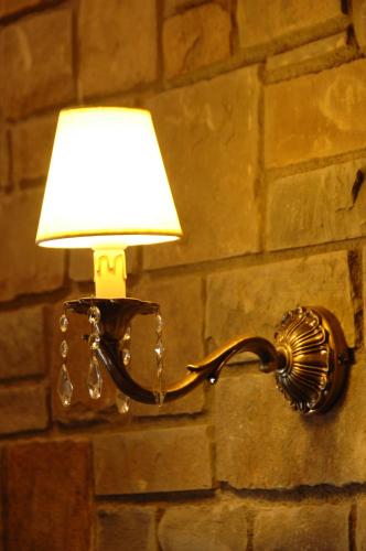 a light attached to a brick wall with a lamp at Guesthouse Iridanos in Kalabaka