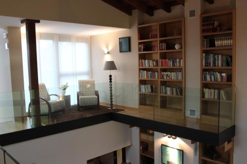 a living room with a glass table and bookshelves at La QuintaEsencia in La Pereda de Llanes