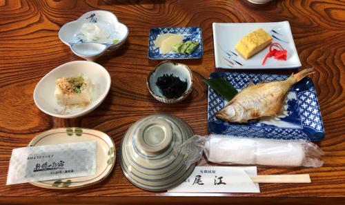 una mesa cubierta con platos y tazones de comida en Minshuku Oe, en Kyotango