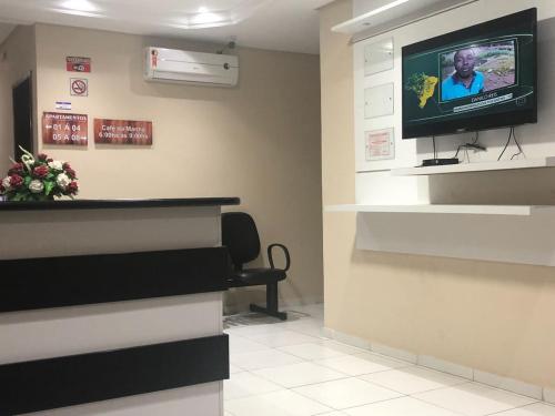 a waiting room with a tv on a wall at Pousada São Lucas in Salgueiro