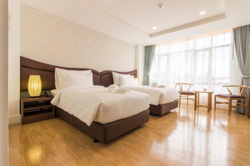 Avada Hotel في ترات: غرفة فندقية بسريرين وطاولة