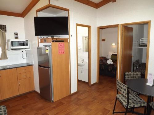 a kitchen with a refrigerator and a table in a room at Ceduna Foreshore Caravan Park in Ceduna