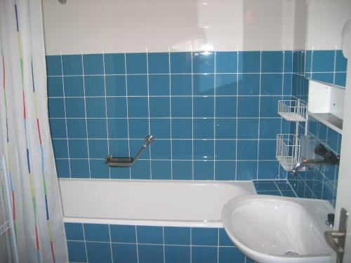 レンツァーハイデにあるAllod (369 St) Whg. Nr. 402の青いタイル張りのバスルーム(バスタブ、シンク付)