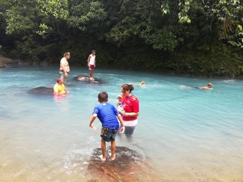 a woman and a boy standing in the water at Cabinas Piuri in Rio Celeste