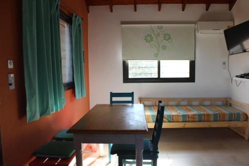 a dining room with a table and a bed at Casa Crisolito in Merlo