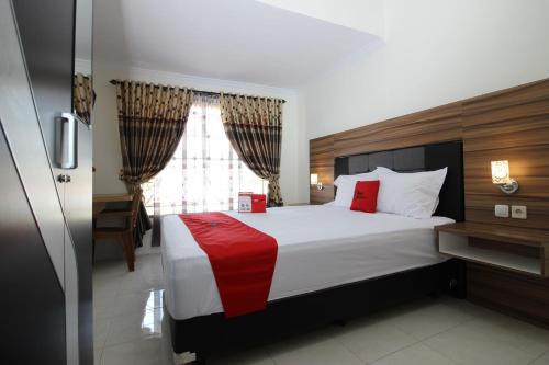 um quarto com uma cama grande e uma janela em RedDoorz near UGM 3 em Yogyakarta
