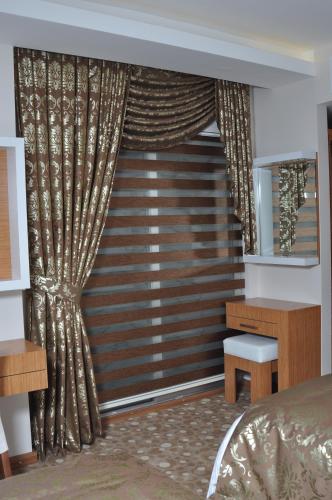 a bedroom with a bed and a window with curtains at Cebeciler Hotel in Trabzon