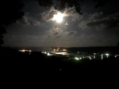 a full moon rising over a city at night at Guesthouse Wasabi in Iki