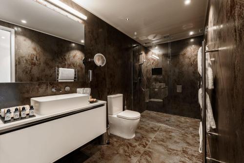 a bathroom with a sink and a toilet and a shower at Plume Villas in Matakana