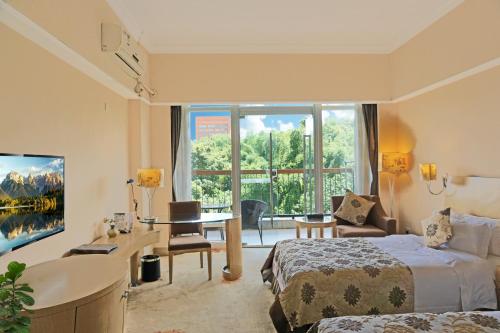 a hotel room with a bed and a desk and a window at University Town International Hotel in Guangzhou