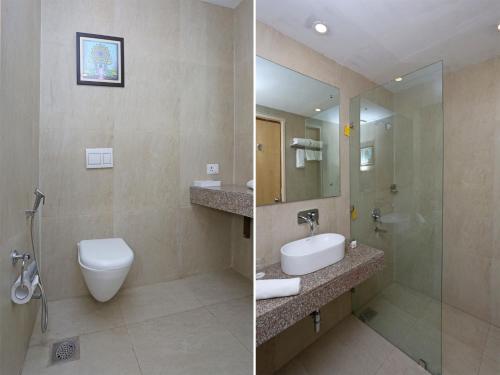 a bathroom with a toilet and a sink and a mirror at Four Leaf Service Suites, Haridwar in Roorkee