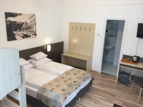 米什科爾茨的住宿－Pizza Tábor Apartman，酒店客房配有一张床、一张书桌和一张书桌。