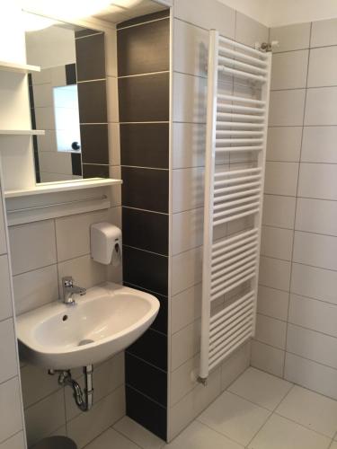 uma casa de banho com um lavatório e um espelho em Pizza Tábor Apartman em Miskolc