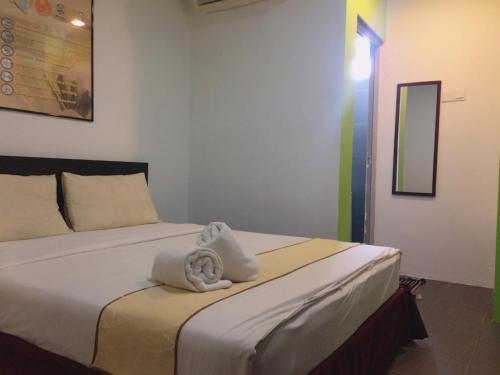 a bedroom with a bed with towels on it at Metroinn Hotel in Arau