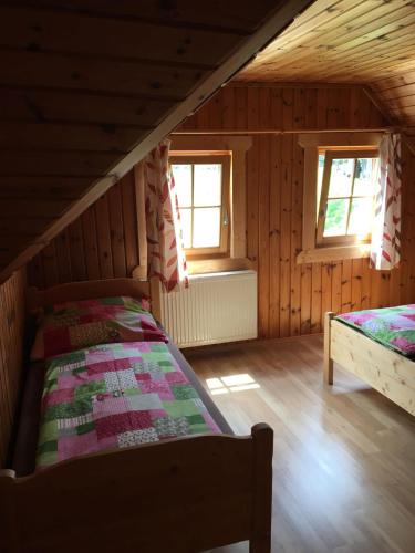 a bedroom with two beds in a wooden cabin at Haus Katrin in Sankt Marein bei Knittelfeld