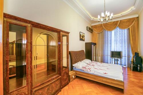 um quarto com uma cama e um lustre em КВАРТИРА У МОРЯ-ЦЕНТР БАКУ em Baku