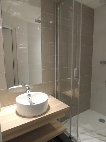 a bathroom with a sink and a glass shower at Best Western Hotel De Paris in Laval
