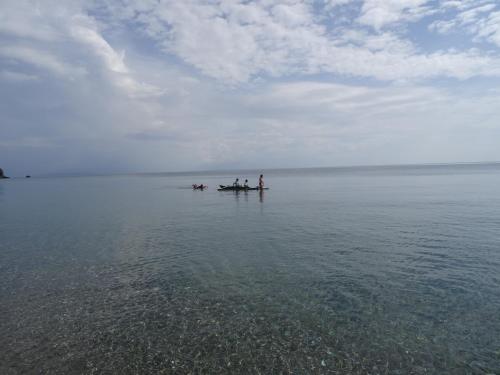 two people and a dog on a boat in the water at Toni Arts Villa in Nabas