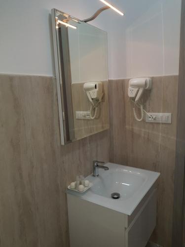 a bathroom with a white sink and a mirror at Residenza Lumière in Termoli