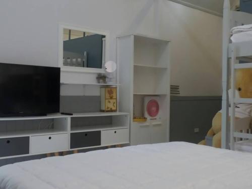 a bedroom with a bed with a tv and a dresser at Baan JaoKorKluay บ้านเจ้ากอกล้วย in Chiang Rai