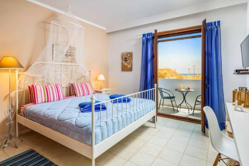 a bedroom with a bed and a balcony with a table at Lindos Sapphire in Líndos
