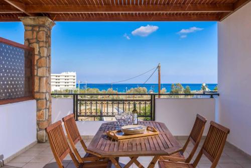 a table and chairs on a balcony with a view of the ocean at Villa Krini Panos in vlicha