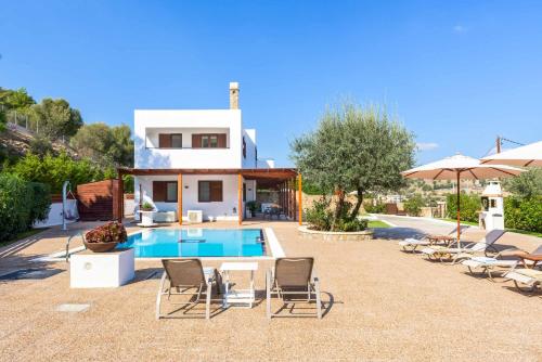 a villa with a swimming pool and chairs and a house at Villa Krini Panos in vlicha