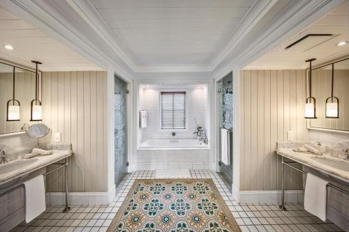 a bathroom with two sinks and a bath tub at Heritage Le Telfair Golf & Wellness Resort in Bel Ombre