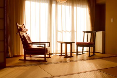 a living room with two chairs and a window at Yugawara Retreat Goen no Mori in Yugawara